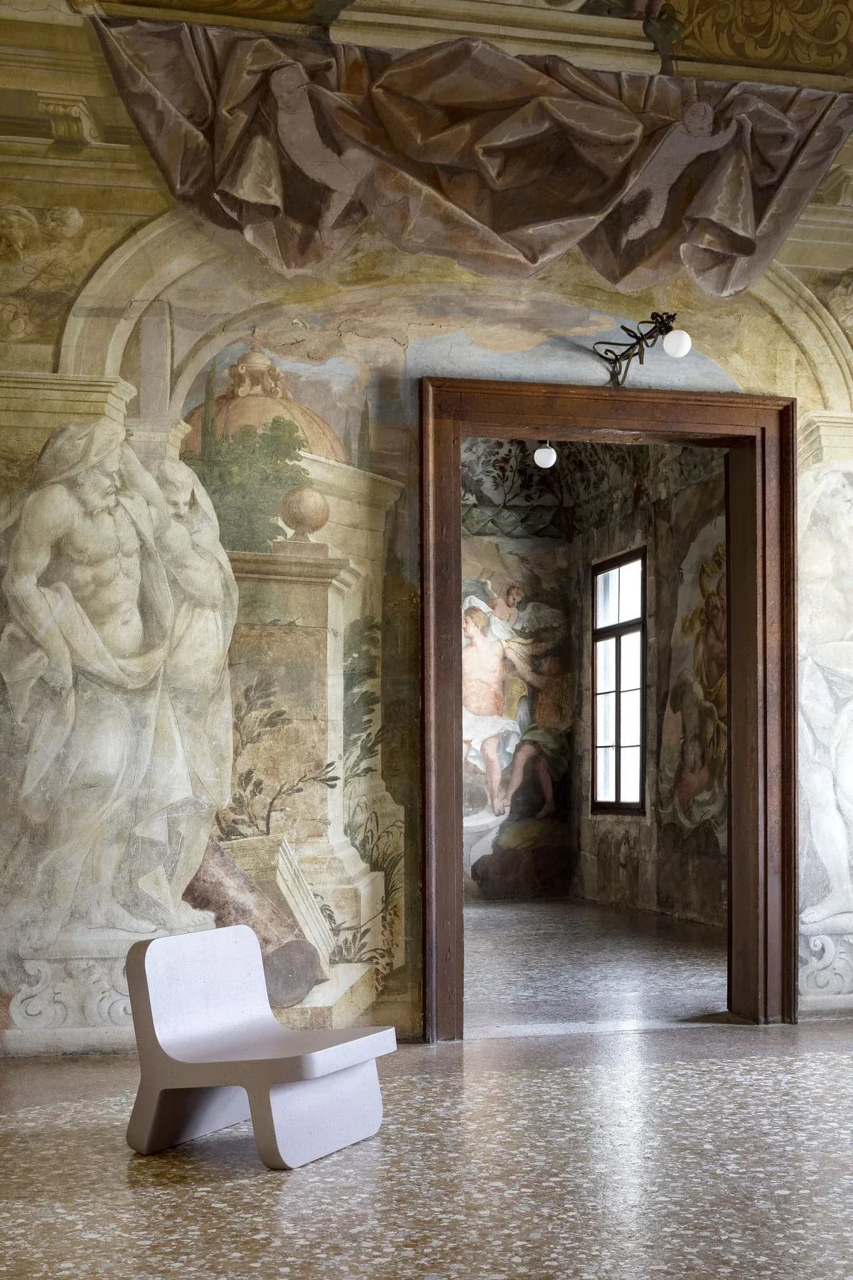 Fauteuil Torcello clair présenté dans un salon vénitien orné de fresques